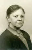 Ateljéporträtt av Karolina* Emilia Gustafsson, född 1873 i Torslanda, död 1949 i Kållered. År 1896 gift med Birger Gustafsson. Dotter till Karl August Eliasson Alm och Emilia Sofia Wessberg, Ekan i Kållered.