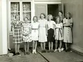Dalsland/Värmland år 1937. Elever och lärare från Kållered är på skolresa. Vid dörren står Ingrid Andersson (1918 - 2001, gift Skansing) som var medhjälpare på resan. Skolresan gick genom Dalsland/Värmland till den norska gränsen och anordnades av Daga och Gunnar Alander (folkskollärare i Kålleredsskolan). 
Relaterade motiv: A3101, A3103 - A3108.
