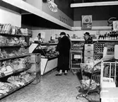 Bild inifrån Konsumbutik på Sjömansvägen i Stockslycke. Bilden visar några kunder framför köttdisken. Butiken öppnades 1957.