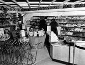 Butiksinteriör från Konsumhallen, Norra Strömgatan kv. Väduren (Folkets hus). Två kvinnor vid bakre väggen och kassan till höger.
