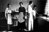 Köket på Törnbloms konditori, Färgaregatan, kv Pärlan. Anna Törnblom med syster Edith Claesson-Bulir samt två okända kvinnor vid disken.