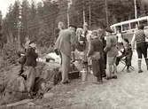 Fikastund för elever och lärare från Kållered som är på skolresa år 1937. Resan gick genom Dalsland/Värmland till den norska gränsen och anordnades av Daga och Gunnar Alander (folkskollärare i Kålleredsskolan). Ingrid Andersson (1918 - 2001, gift Skansing) var medhjälpare på resan. 
Relaterade motiv: A3101, A3103 - A3108.