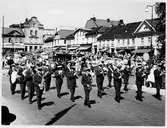 Barnens dag 1960. Musikkår går i parad förbi folksamlingen på torget.