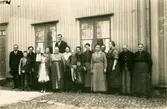 Anställda vid Alingsås bomullsväveri, gamla fabriken. 
Uppställda på Gamla tingshusets gård, kvarter Spinnaren. 
Från vänster 
1. Svante Hansson, undervävmästare (bror till Emma Hansson) 
2. Folke Ahlin 
3. Gerda Ahlin, väverska. 
4. Mor Ahlin, (troligen Stina Kajsa Ahlin), väverska 
5. Ester Brandts dotter 
6. Terese Ahlin, väverska
7. Mor Brandt, väverska
8. Harry Brandt
9. Linnea Karlberg
10. Fransson, väverska
11. Berglot Karlberg, väverska
12. Helge Hansson, barnbarn till Emma Hansson
13. Anna Hansson, väverska, svärdotter till Emma Hansson
14. Hilda Hagberg, väverska
15. Albertina Hagberg, väverska
16. Ester Brandt, väverska
17. Emma Hansson, väverska
18. Kristina ? Förestånderska på väveriet