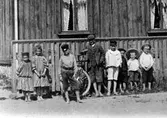 En grupp barn utanför ett hus på Götgatan, kv Bojen. Delförstoring av en bild.