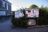 Anslagstavlor i Lindome centrum den 4 oktober 2016. Till vänster ses även del av huset Almåsgången 1 som inrymmer Druvan Pizzeria. Vy mot söder.