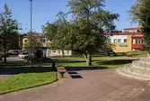 Vy från den lilla parken mot huset Almåsgången 7. Lindome centrum den 4 oktober 2016. I byggnaden ligger Lindome Apotek. Vy mot sydväst.