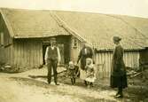 Tre vuxna och två små barn står utanför ladugården vid Livered 