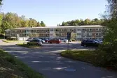 Längst upp på Sagbrovägen i Lindome den 4 oktober 2016. Vy över en parkeringsplats mot ett av husen i bostadsområdet Dotegården. Huset har adresserna Dotegården 23-26. Vy mot öster.