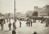 Stortorget i Växjö, en marknadsdag ca. 1900. Till höger ser man stadshotellet/stadshuset. I bakgrunden syns husen längs Kronobergsgatan (kvarteret Lejonet) och domkyrkans torn.