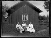 Kvinnor med barn framför hus