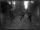 Tre män med cyklar
