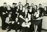 Avslutningsfest för de killar* (födda 1918) som skulle ut i militärtjänstgöring, Blå Bandföreningens stuga i Tulebo, vintern 1938 - 39. 1. Hildur Nilsson, Tulebo. 2. (sommargäst i Tulebo) Ingalill Dahlberg Börjesson, Burås, Göteborg. 3. Thure Johansson Bjerrhede*, Vommedal. 4. Gunnar Nilsson, Tulebo. 5. (sommargäst i Tulebo) Eivor Dahlberg Bjerrhede, Burås, Göteborg. 6. Rune Pettersson*, Klippan, Vommedal. 7. Okänd. 8. Harding Gustavsson*, Tomtebovägen, Kållered. 9. Kurt Johansson (1917 - 1995). 10. Kerstin Mattsson (1920 - 2007). 11. Dagmar Johansson Svensson, Vommedal. 12. Sven Svensson, Vommedal. 13. möjligen Ingrid Andersson Skansing eller hennes syster Astrid Andersson Dahl. 14. Inga-Britt Johansson (Dagmar Johansson Svenssons syster, tvilling med nr 20). 15. Kalle Nilsson, Tulebo. 16. Märta Andersson Nilsson, Livered. 17. Bertil Nilsson (1911 - 1976), Fagered, Lindome. 18. Kurt Andreasson. 19. Bertil Jägrud*, Hallen. 20. Ann-Marie Johansson (Dagmar Svenssons syster, tvilling med nr 14). 21. Nisse Winkvist, Tulebo. Relaterat motiv: A0736.