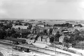 Laholms stad sett från silostak. Stationsområdet med järnvägsspår,  järnvägsvagnar  och magasin, men byggnaden som det står 