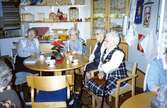 Några kvinnor sitter till bords och dricker kaffe i Brattåsgårdens hobbylokal på Vommedalsvägen, cirka 1990 - 1991. Från vänster: 1. Elin Jansson (1905 - 1991). 2. Okänd. 3. Rut Göransson (1905 - 1999). 4. Alida Ekström (1896 - 1994).