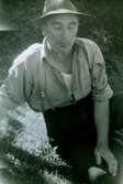 Erik Bengtsson (född i Dammkärr, Tulebo 1899 - död 1991 i Vommedal) sitter på gräsmattan och vilar, Heljered Sörgård 