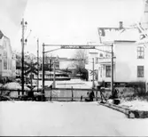 Bommarna vid järnvägskorsningen på Bäckgatan har ersatts med ett staket. Till vänster, på andra sidan spåret, syns Missionskyrkan i kv Skepparen.