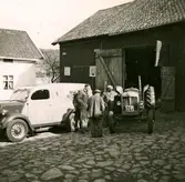 Gårdsplanen vid Ekans gård, Ekan 1:1, år 1953. Från vänster: traktorreparatör Malte (i basker). 2. (rygg mot kameran) drängen Robert Pettersson (1886 - 1968). 3. Rolf Svensson (1909 - 1989), ägare av gården. 
Relaterat motiv: A1147 och 1149.