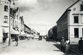 Storgatan, korsningen mot Bäckgatan, Växjö 1923. Till vänster ser man (närmast) familjen Feuks fastighet (kvarteret 
Klostret 8), med bl a Oscar Karlssons uraffär, följt av diverse andra hus i kvarteren Klostret och Sunaman. Till höger ser 
man bl a apoteket Sigfrids lokaler i kvarteret Blenda (Blenda 1).