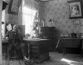 Oidentifierad man i hemmiljö. Mannen bilden är troligtvis bekanta med fotografen, Nanny Ekström. Eventuellt är detta fotografens svåger, Ebbe Stensbäck.