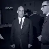 Bild i samband med militärövningen Ölandskriget. Herrar i kostym vid långbord.