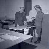 Bild från militärövningen Ölandskriget. Ett befäl i telefon och en kvinna, troligen från Kvinnliga bilkåren, som håller i ett häfte.