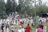 Barn och vuxna dansar kring stången vid midsommarfirande på Ekensås cirka 1982.