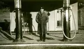 Troligen John Johansson (1898 - 1966) från Nygård, busschaufför för Kållered Bussbolag, står mellan två bensinpumpar vid Caltex Texacostation, 1940-tal. Bensinstationen låg vid nuvarande Streteredsvägen och Gamla Riksvägen i Kållered centrum.