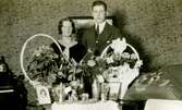 Uppvaktning för en man och en kvinna som står bakom ett bord fullt med blommor, Kållered Stom 