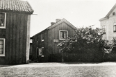 Bostadshus i kvarteret Ödman, Växjö, ca 1910. På mittenhusets gavel syns en skylt: 
