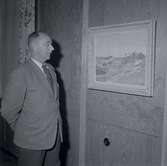 Troligen Karl Viktor Herbert Prim 1910-1998 som står och tittar på en tavla. Bild ifrån nybyggda godtemplargården i Borgholm.