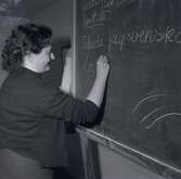 Bild tagen i samband med att flyktingar ifrån Ungern anlände 1956. Kvinna som skriver på en tavla i Godtemplargården. Hösten 56 - våren 57.