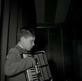 Bild tagen i samband med att flyktingar ifrån Ungern kom 1956.  Pojke som spelar dragspel i Godtemplargården hösten 56 - våren 57.