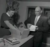 Gärdslösa kommungård (förut ålderdomshem) i biblioteket. Två personer hanterar böcker.