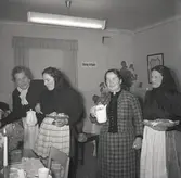 Damer tillhörande en kvinnoklubb för kroppkakor. Serverar kaffe.