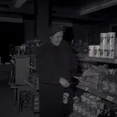 En kvinna bland varor i Konsum.