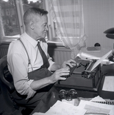 Axel Nilsson sitter vid en arbetsbänk med skrivmaskin och dokument, Borgholm.
