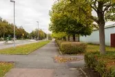 Idrottsvägen vid Åby Fritidscentrum i Åby, Mölndal, den 11 oktober 2016. Vy österut från gångvägen till höger om cykelbanan och bilvägen.