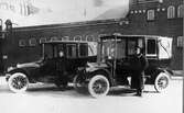 Åkeriets bilstation vid Västerbro. Bröderna Karl och Janne Rydén fotograferade vid två av droskbilarna i början på 1910-talet.