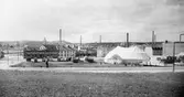 Cirkus Frankoni gästar staden och slagit upp sitt tält på den gamla tivoliplatsen i kvarteret Vulkanus vid Bryggaregatan. T.v. Borås Tryckeri & Kartongfabrik. Foto från början av 1920-talet.