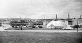 Cirkus Frankoni gästar staden och slagit upp sitt tält på den gamla tivoliplatsen i kvarteret Vulkanus vid Bryggaregatan. T.v. Borås Tryckeri & Kartongfabrik. Foto från början av 1920-talet.