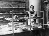 Fru Selma Broberg vid disken i sin bageributik vid Norrby Långgata omkring år 1915.