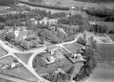 I förgrunden syns Berga kyrka m.m. Till höger syns prästgården och snett bakom den fastigheten Holmsborg och ån Lagan.