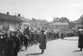 Elever på marsch till Idrottsplatsen (Ramnavallen) den 6:e juni år 1930. Fotot är taget vid Sven Eriksonsplatsen.