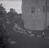 Människor som vandrar i folkdräkter på Kalmar slott. Orkester som spelar med violiner.