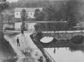 Tre herrar vid en stenbro över Viskan, Sven Eriksons väg. I bakgrunden syns Rydboholms kyrka innan klocktornet byggdes.