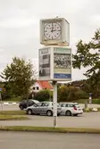 Större klocka på en stolpe vid parkeringsplats tillhörande Åbytravet i Åby, Mölndal, den 11 oktober 2016. Stolpen har även plats för reklam.