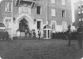 Kung Gustav V:s besök i Borås 1924. Folksamling vid Älvsborgs regementes 300-års jubileum. Kungen kommer ut från entrén och hälsar soldaterna med honnör.