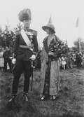 Kung Gustav V:s besök i Borås 1924. Man i uniform bredvid en kvinna som håller en bukett blommor.