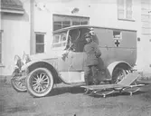 En förare står bredvid en ambulans med bår.